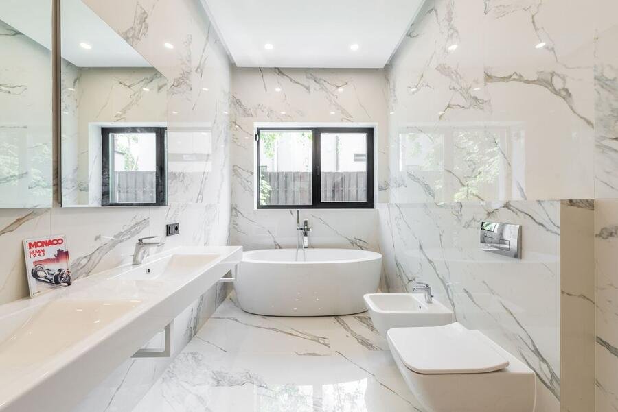 Spacious white marble bathroom with twin windows