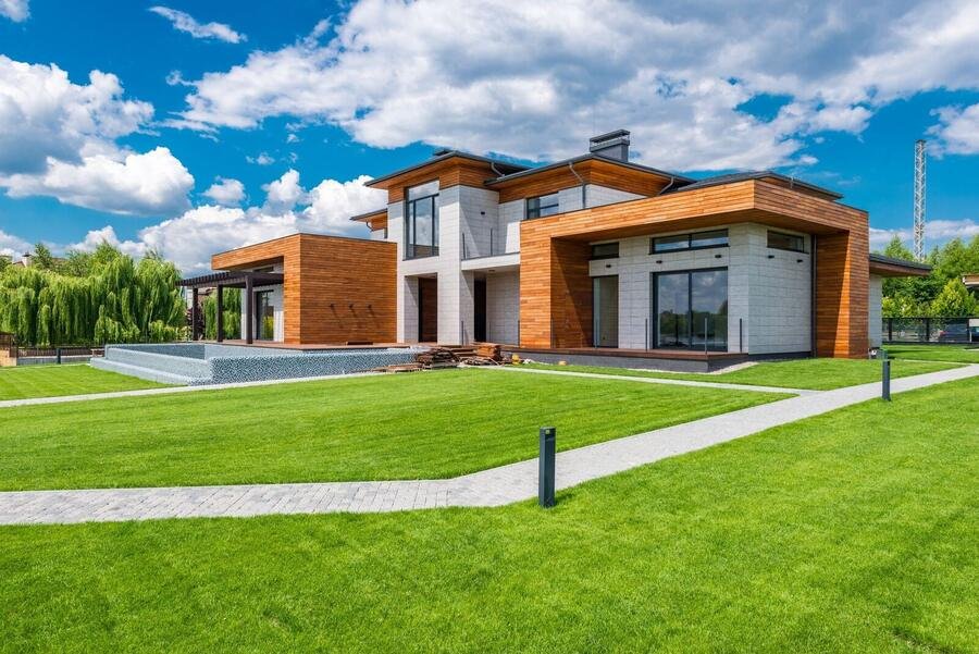 Modern luxury custom home with timber and stone facade and manicured lawn