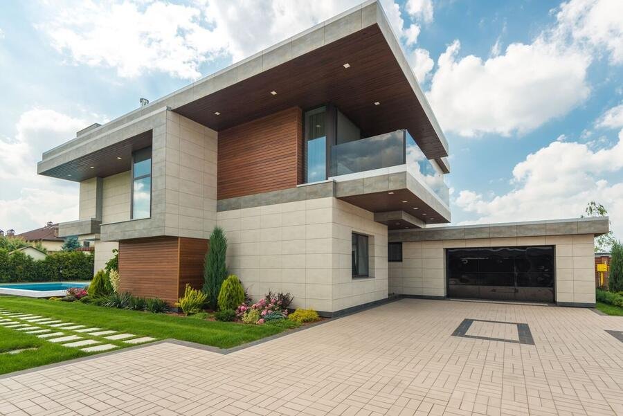 Custom home entrance with sculpted landscaping and stone paving