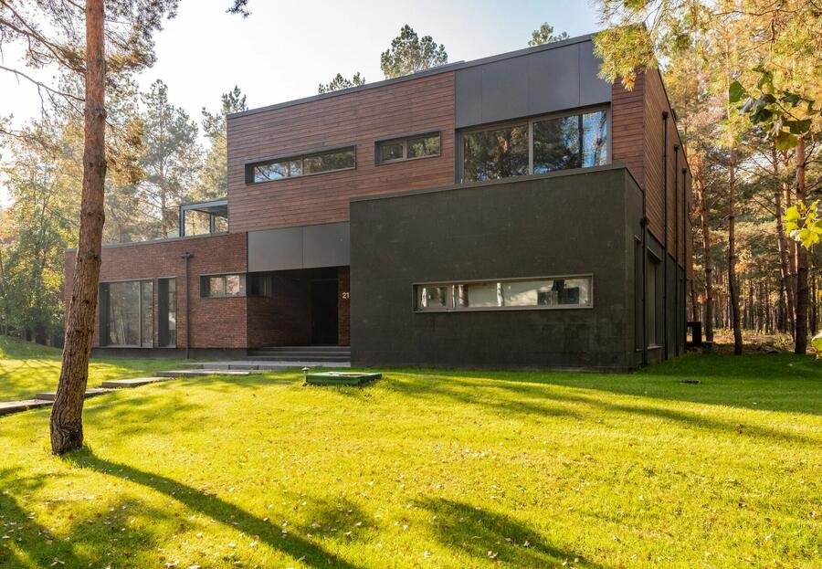 Architectural home with dark cladding nestled among trees