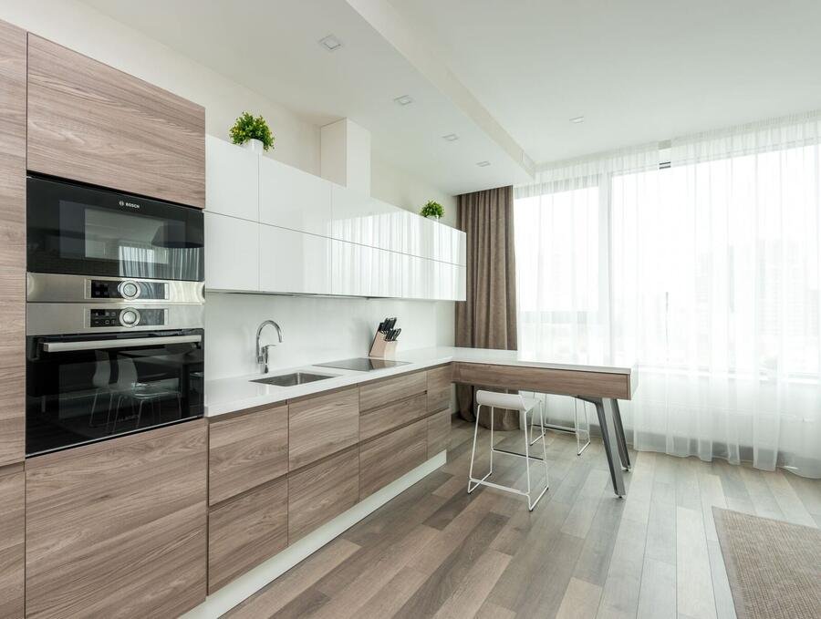 Sleek white kitchen with glossy cabinetry and natural light