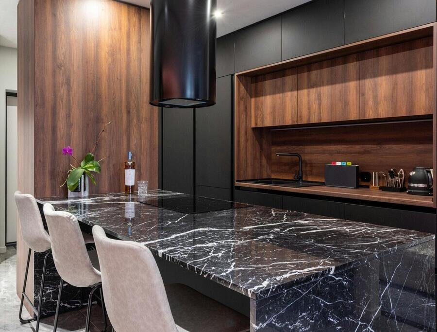 Dark green and walnut kitchen with textured stone